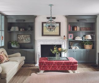 Living room with dark blue bookshelves and red footstool