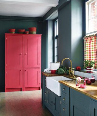 Blue kitchen, red, pink cupboard, grey units, butler sink