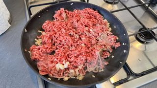 Ground beef, onions, and garlic in a frying pan