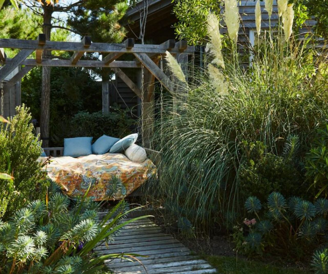 A pergola with sofa bed in a garden