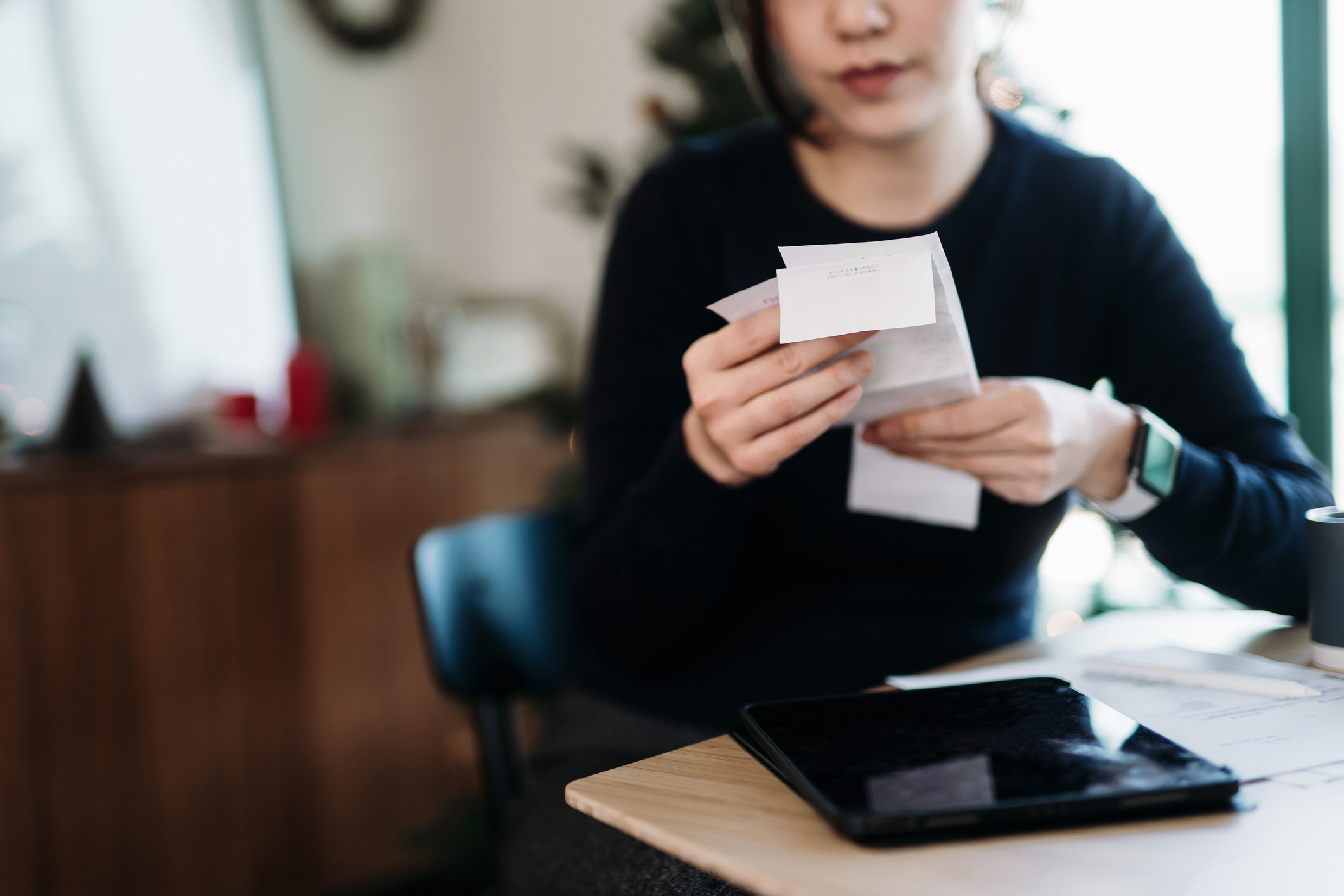 Woman looks at receipt from weekly shop