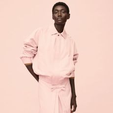 Woman wears pink jacket, pink skirt