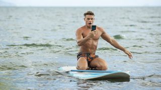 Callum Hole on a boogie board in the water in Love Island Games key art