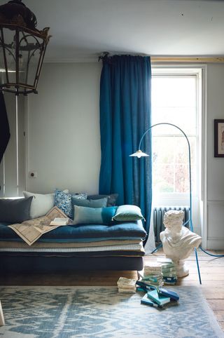Grey living room with blue curtains and a lantern pendant light