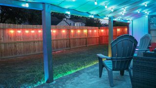 A shot of a porch and backyard fence with Govee's outdoor string lights hanging on them