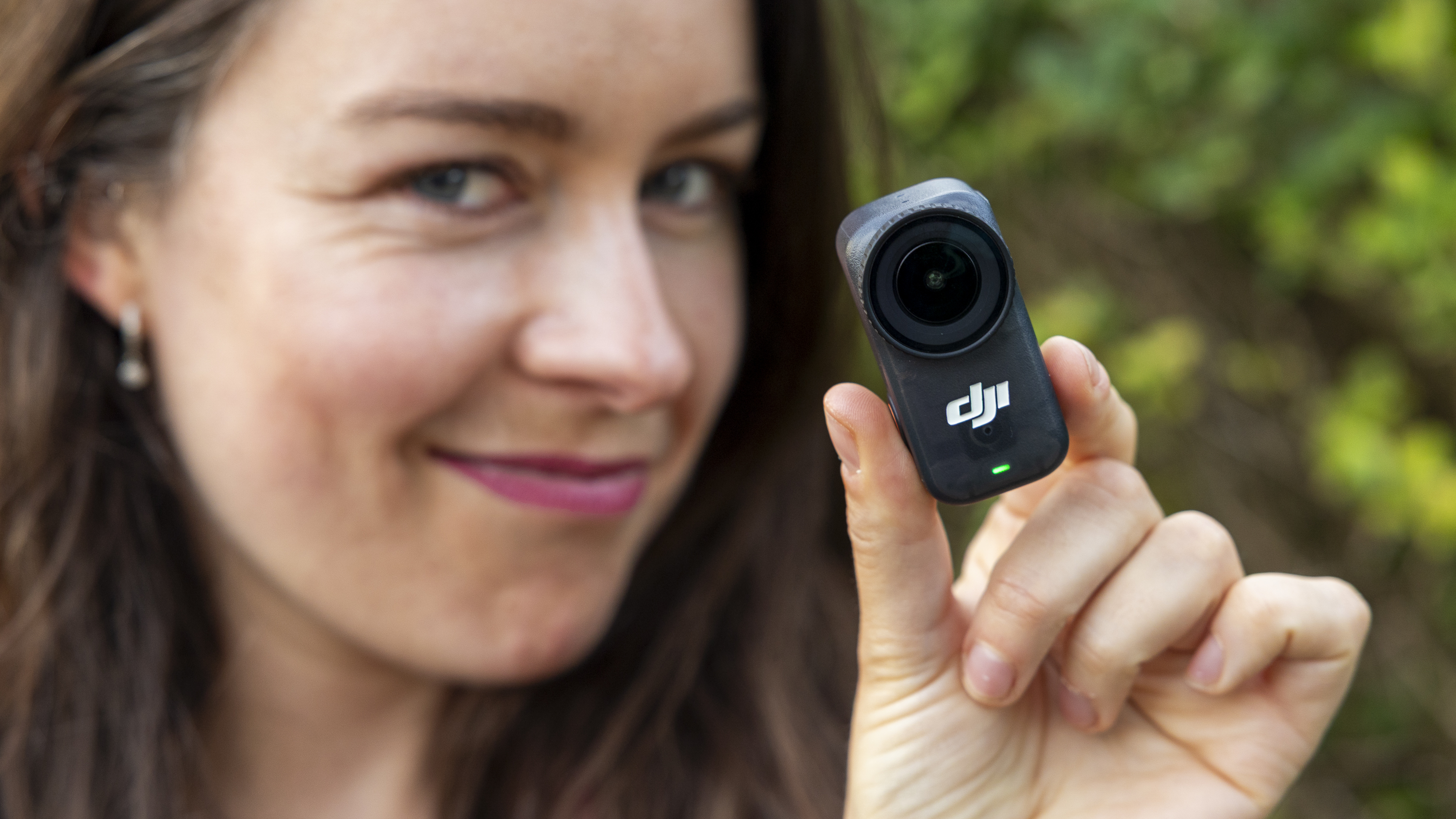 The DJI Osmo Nano camera held by a female photographer in a pink top