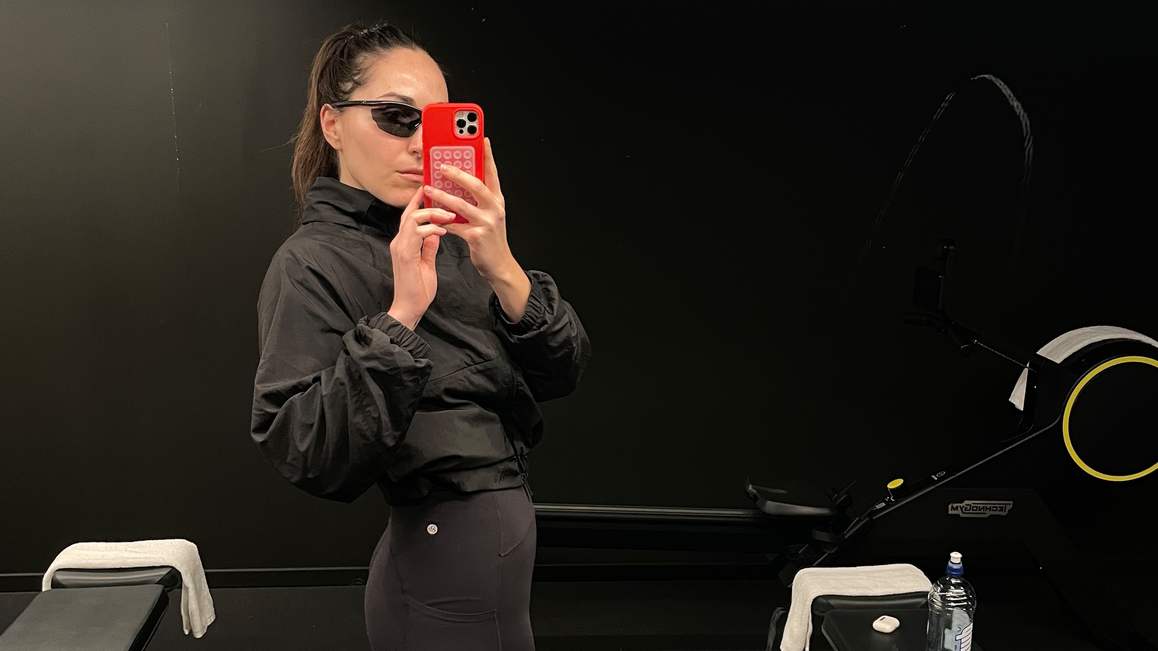 Who What Wear senior fashion editor Anna LaPlaca wearing a windbreaker and bike shorts at the gym.