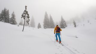 A skier heading uphill in the snow