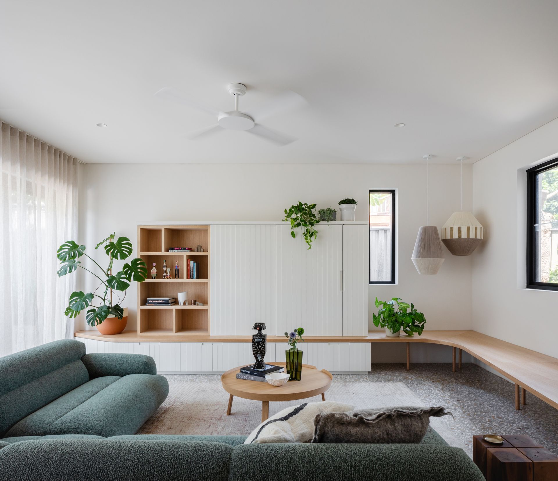 A small living room with the wooden storage unit painted white to match the walls