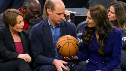 Massachusetts Governor-elect Maura Healey (L) watches as Britain's Prince William is handed a basketball by Catherine, Princess of Wales during the National Basketball Association game between the Boston Celtics and the Miami Heat at TD Garden in downtown Boston,on November 30, 2022.