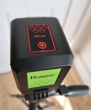 A Huepar B011R laser level device with red On Off button and lime green label