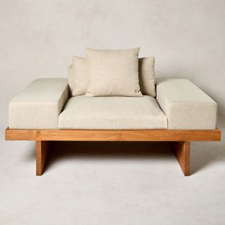 Japandi style snuggle seat for two with generous cushions on top of a low wooden frame