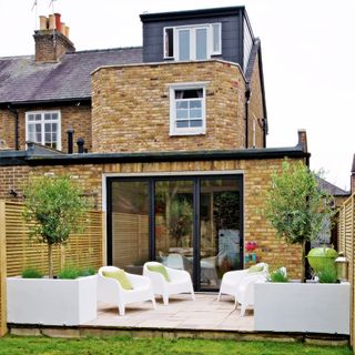 brick house with garden and white armchair