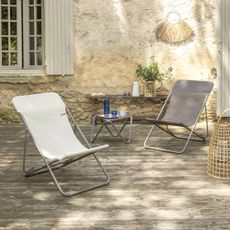 A set of two deckchairs in an outdoor space with a wooden deck