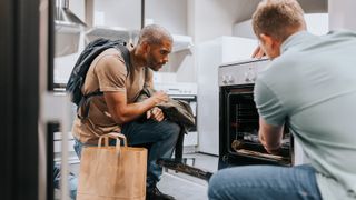 man looking at oven to buy