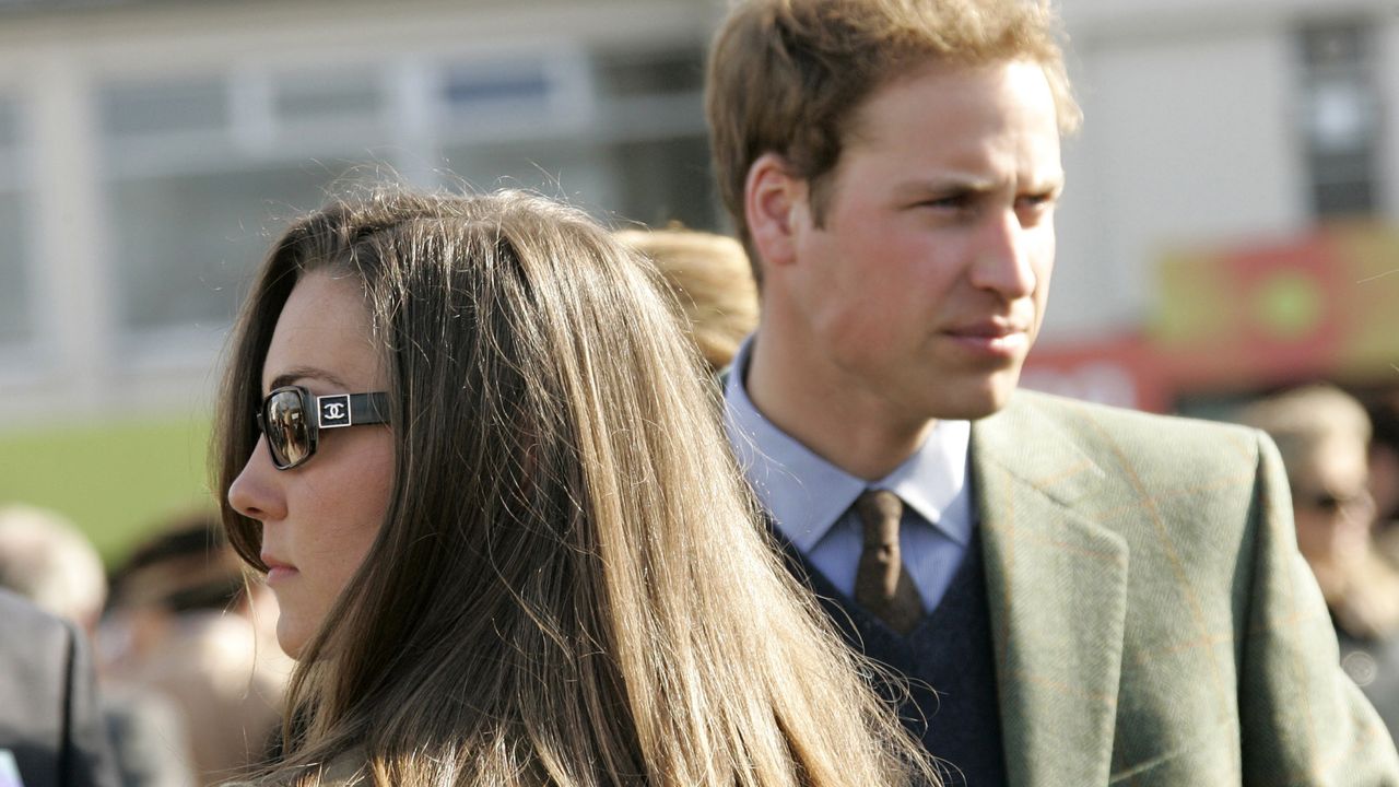 Kate Middleton looking to one side and wearing sunglasses and Prince William looking to the other side