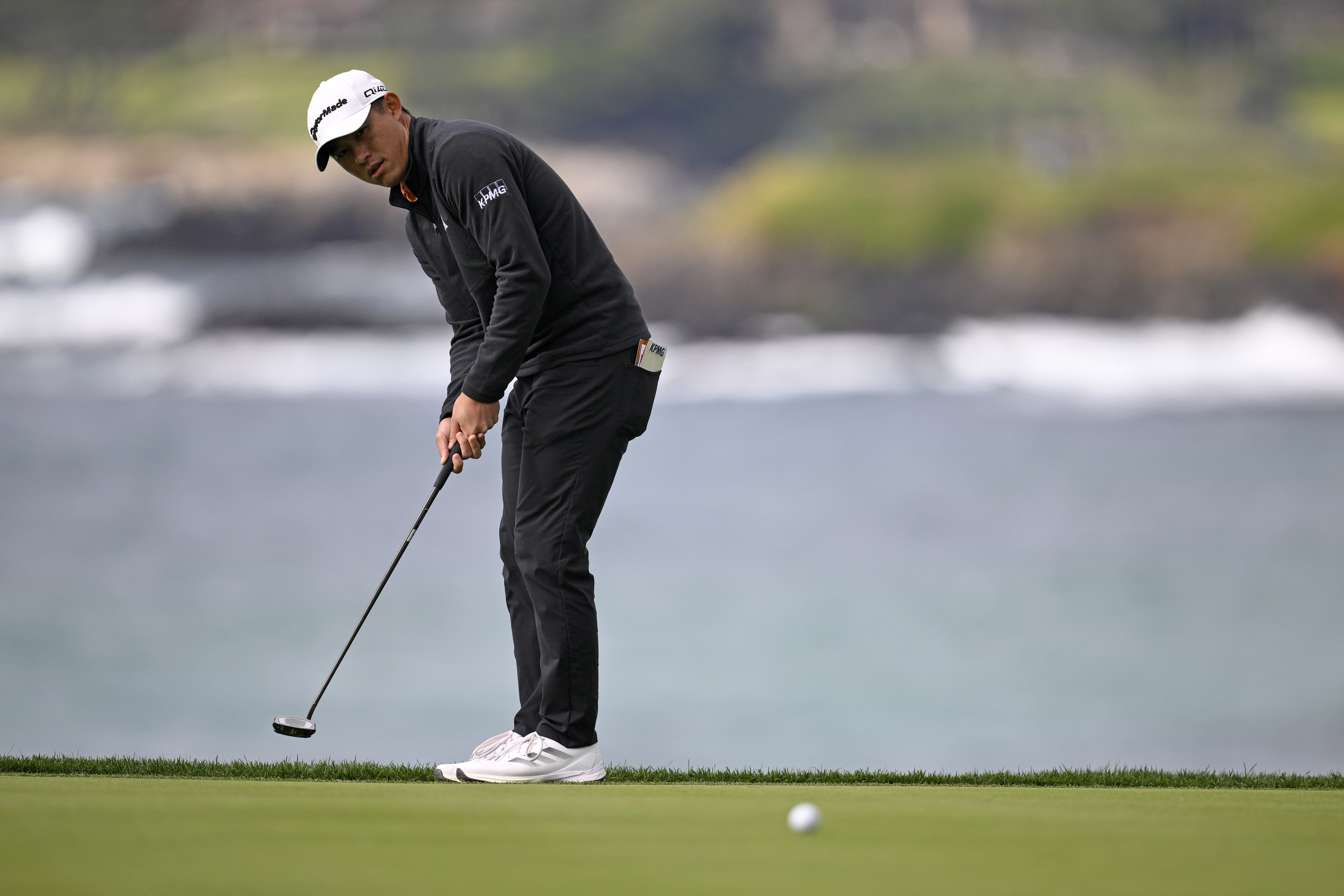 Collin Morikawa hits a putt from off the green