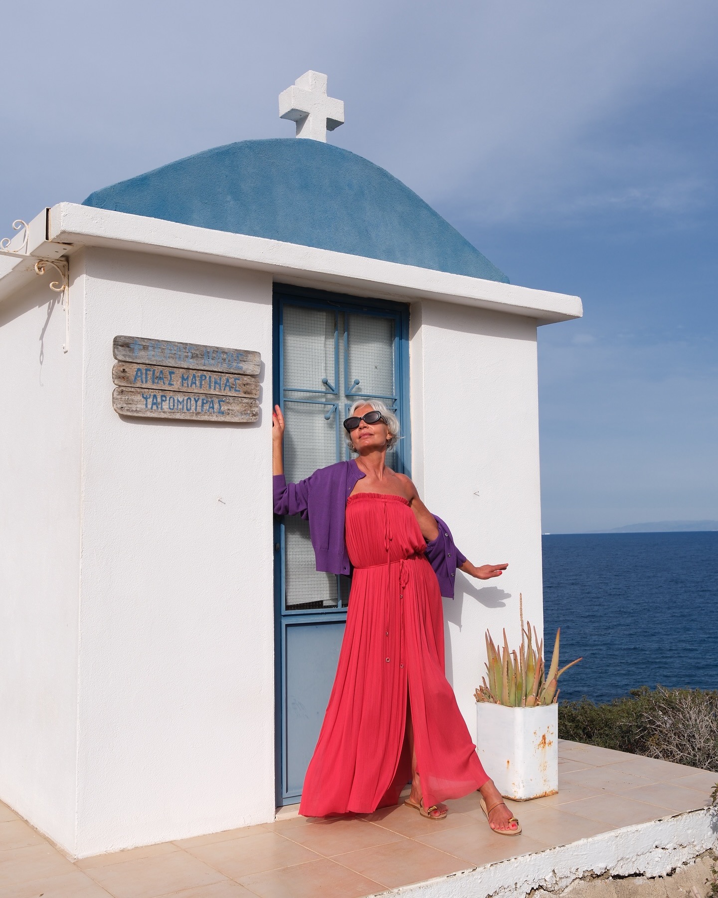Grece wears a purple sweater and pink maxi dress.