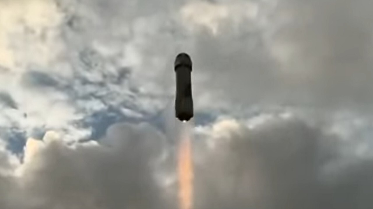 NS-36 太空遊客號發射期間，一枚藍色的新型謝潑德火箭在多雲的天空中映出輪廓。