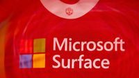 Close-up view of the Microsoft Surface logo printed below the collar on the back of a red Manchester United shirt.