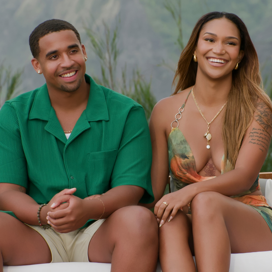 Mikey Bivens and Sydney McGregor sit together on a couch smiling in a still from temptation island season 2