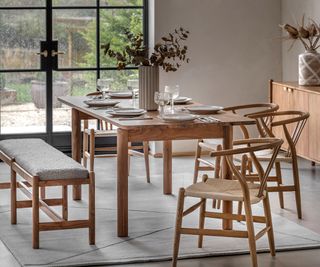 neutral dining room with rectangular wooden dining table and dining bench and chairs and wooden sideboard