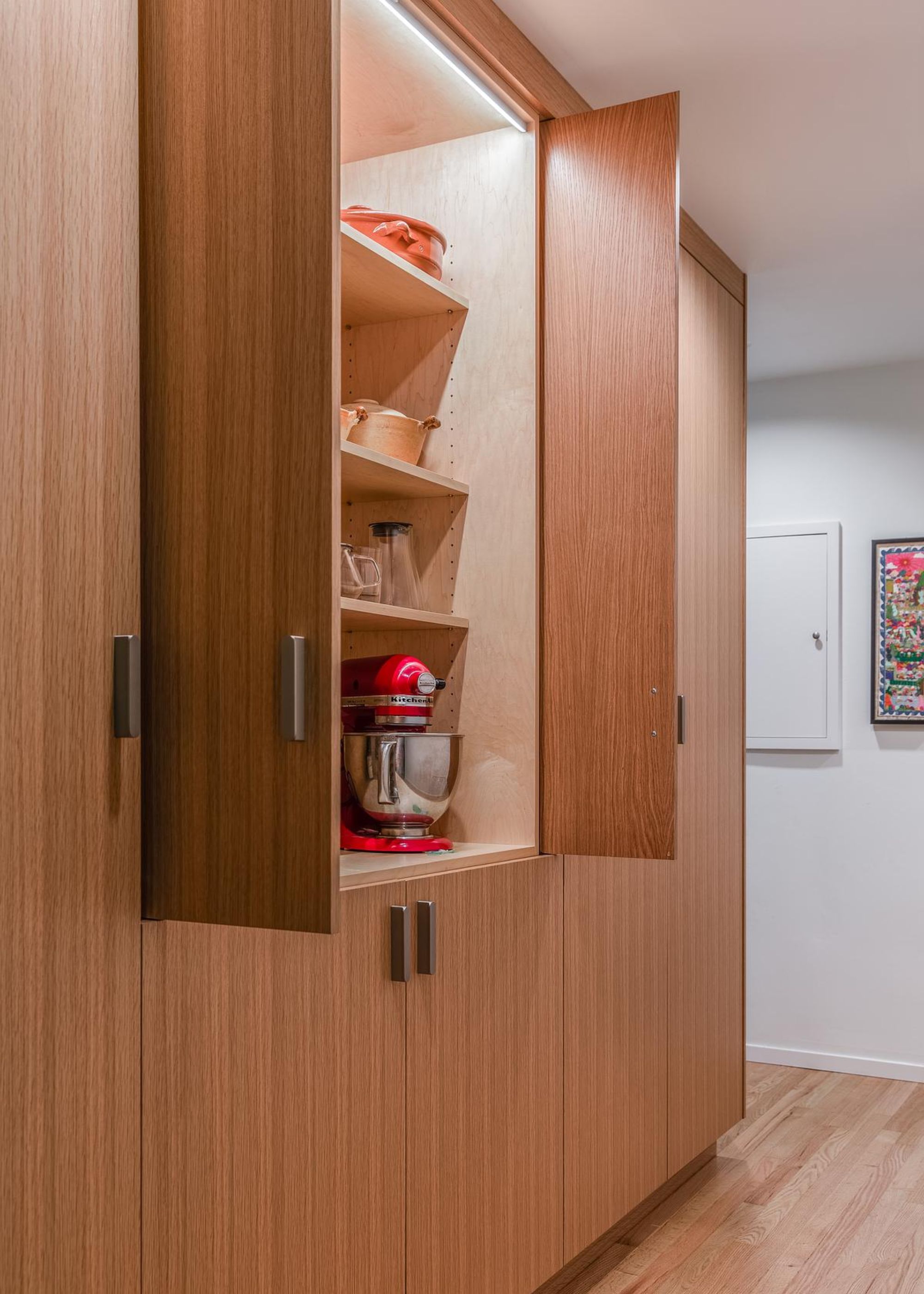 An appliance garage in a kitchen with its doors open and a view of some of the appliances peeking out