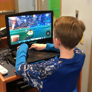 Boy playing video game on laptop computer.