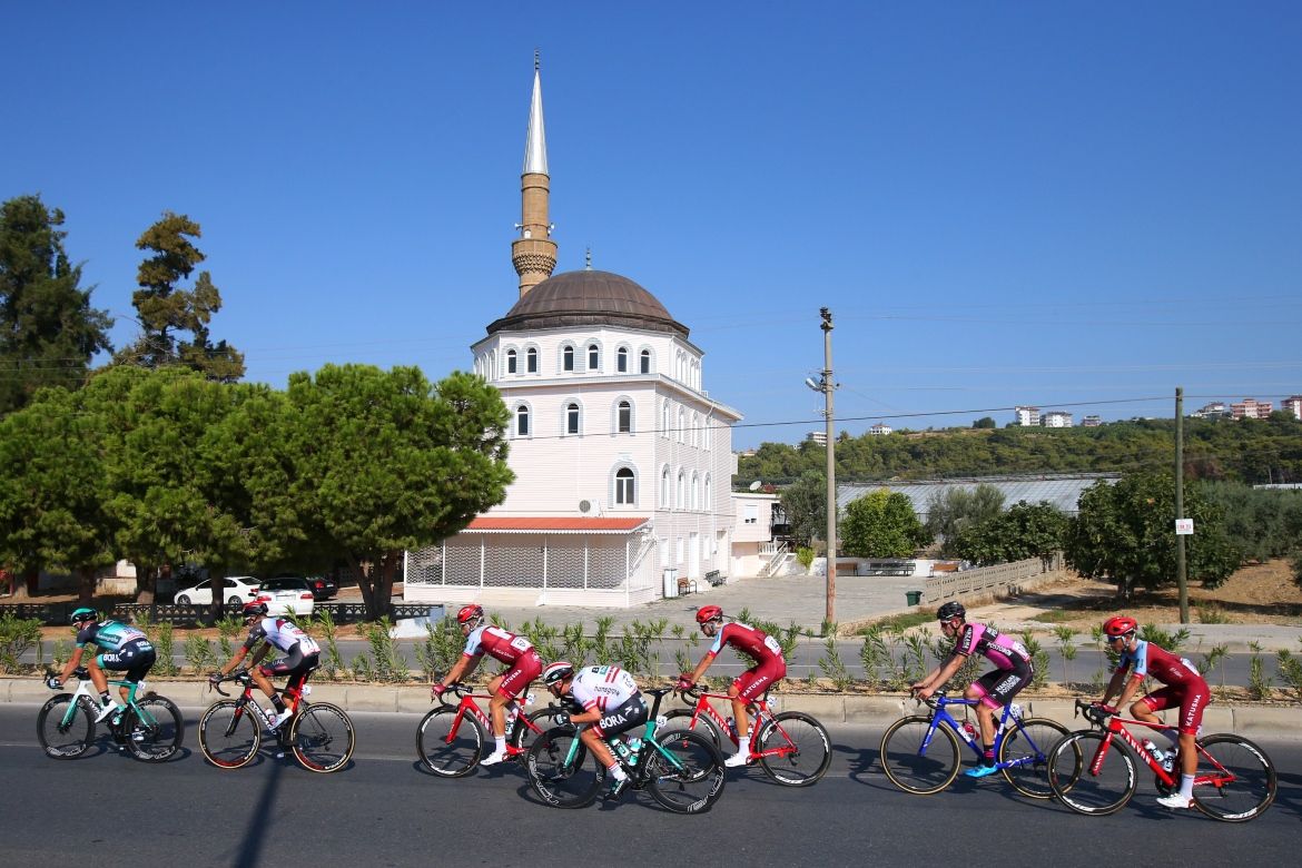The riders pass by a mosque