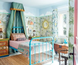 bedroom with blue metal bed, floral decor and small canopy above bed