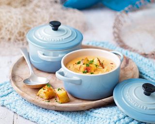 Le Creuset Stoneware Petite Casserole Coastal Blue with soup inside on blue blanket