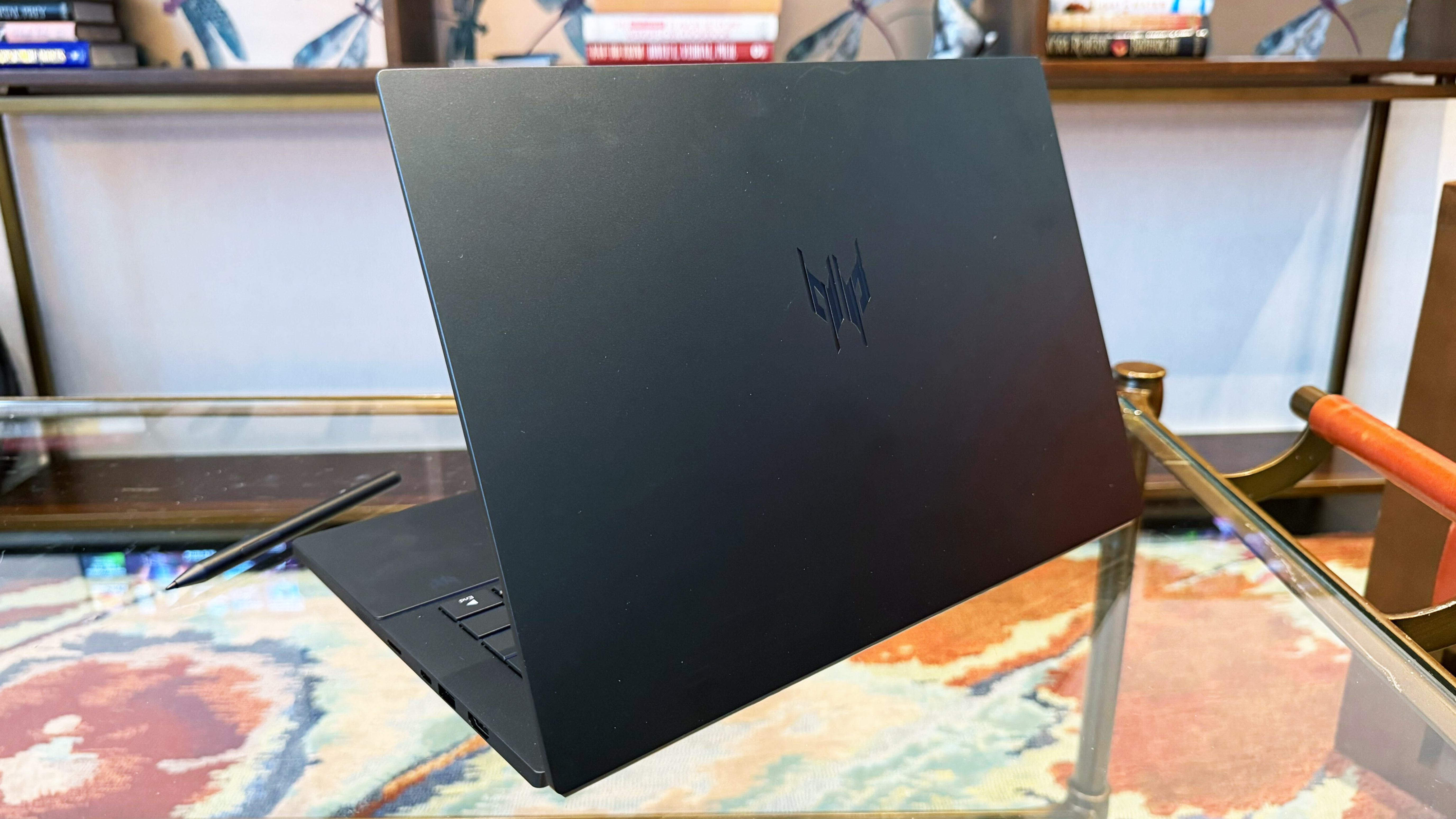Acer Predator Triton 14 AI gaming laptop on a glass table.