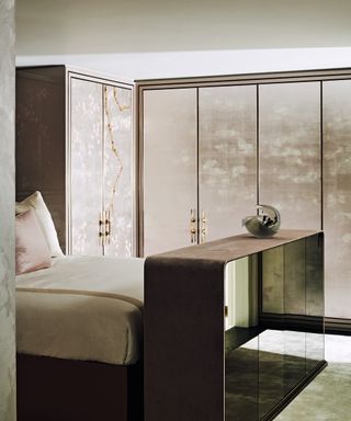 neutral bedroom with a mirrored TV console and custom wardrobes