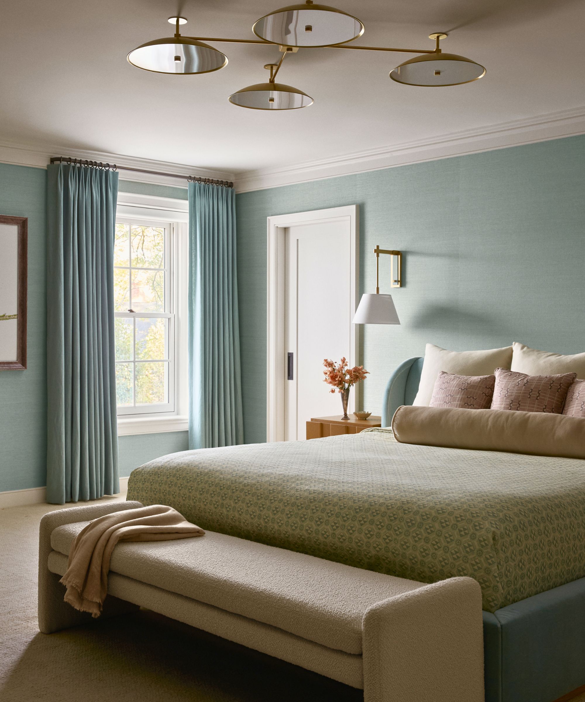 pale blue bedroom with blue bed and beige bench