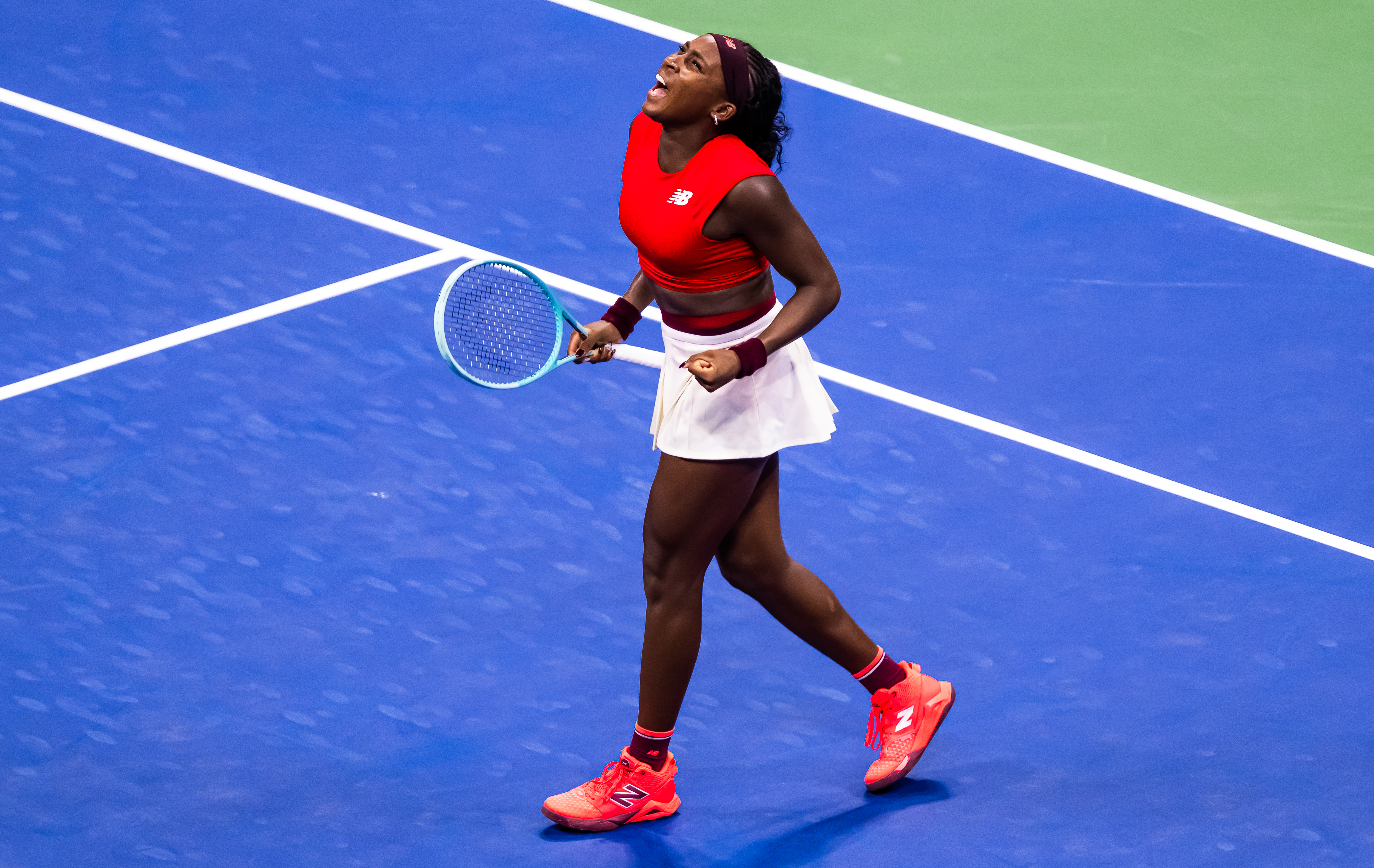 Coco Gauff plays at the 2025 us open in a red and white tennis outfit