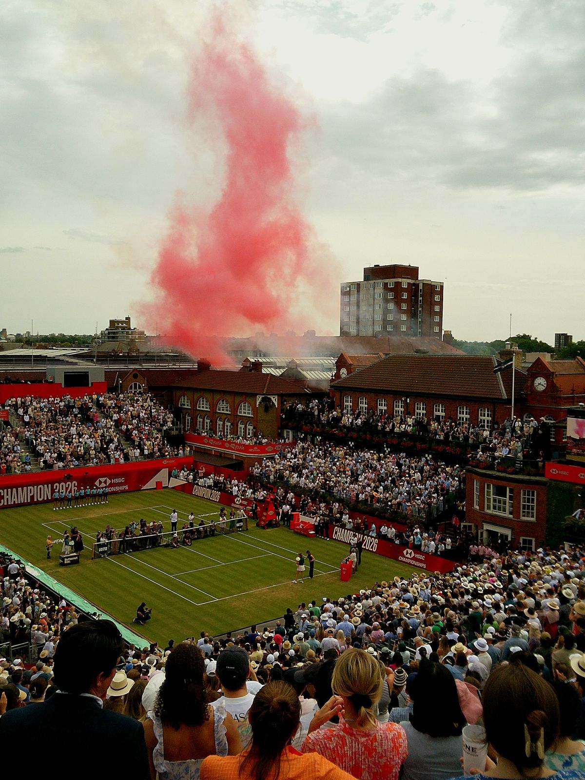 Sample image taken with Camp Snap 2 digital compact camera showing tennis court from distance with red smoke hanging in the air
