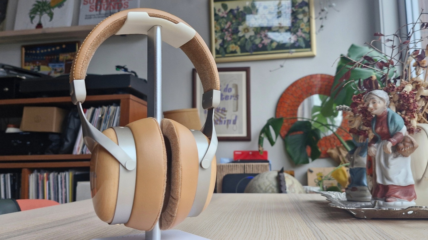 The Sivga Robin SV021 Pro headphones on a stand next to a porcelain figure.