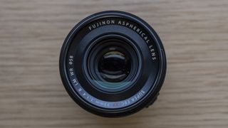 The Fujifilm XF33mm f/1.4 lens on a wooden table