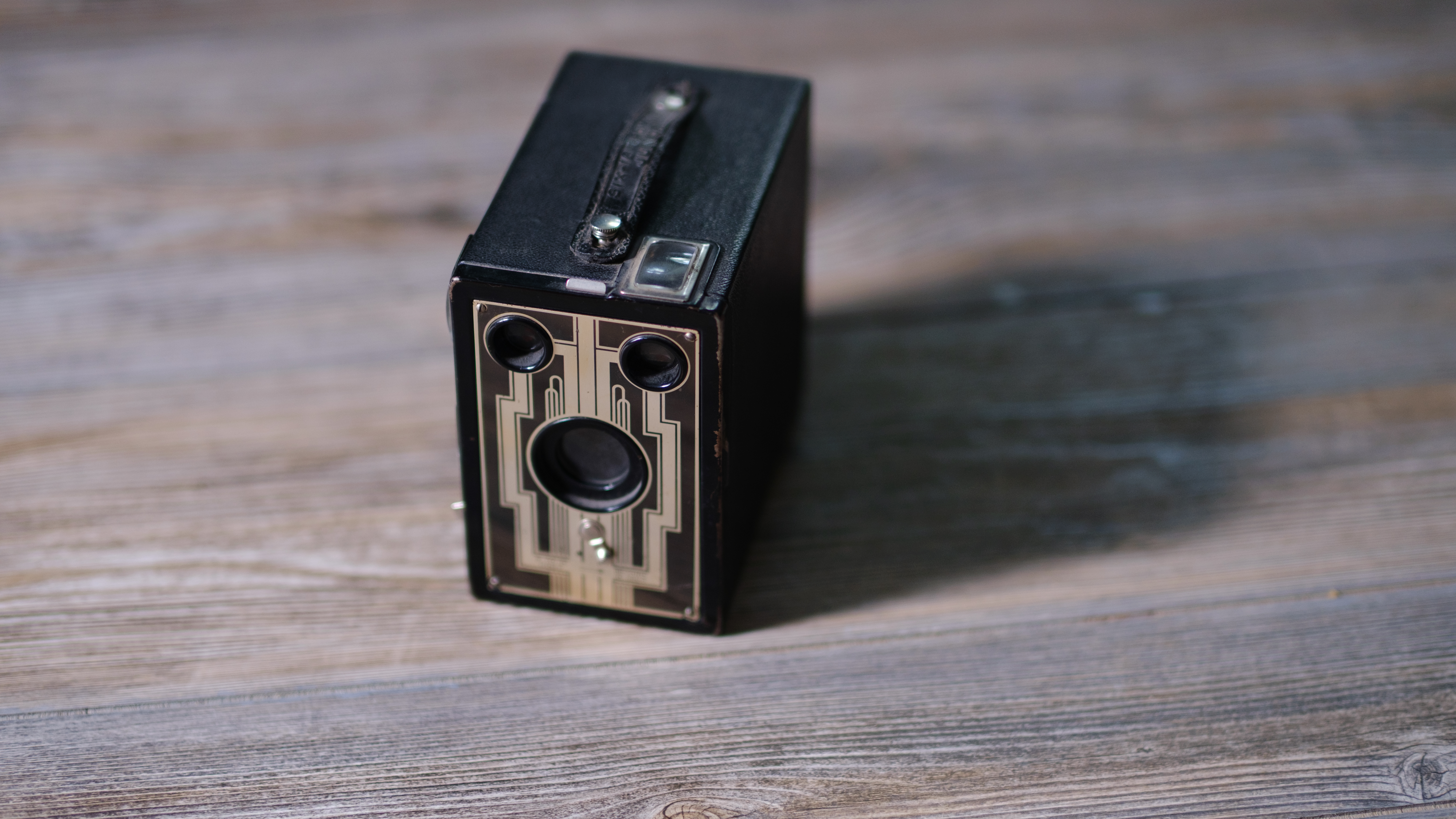 A photo of a vintage box camera taken under different lighting conditions