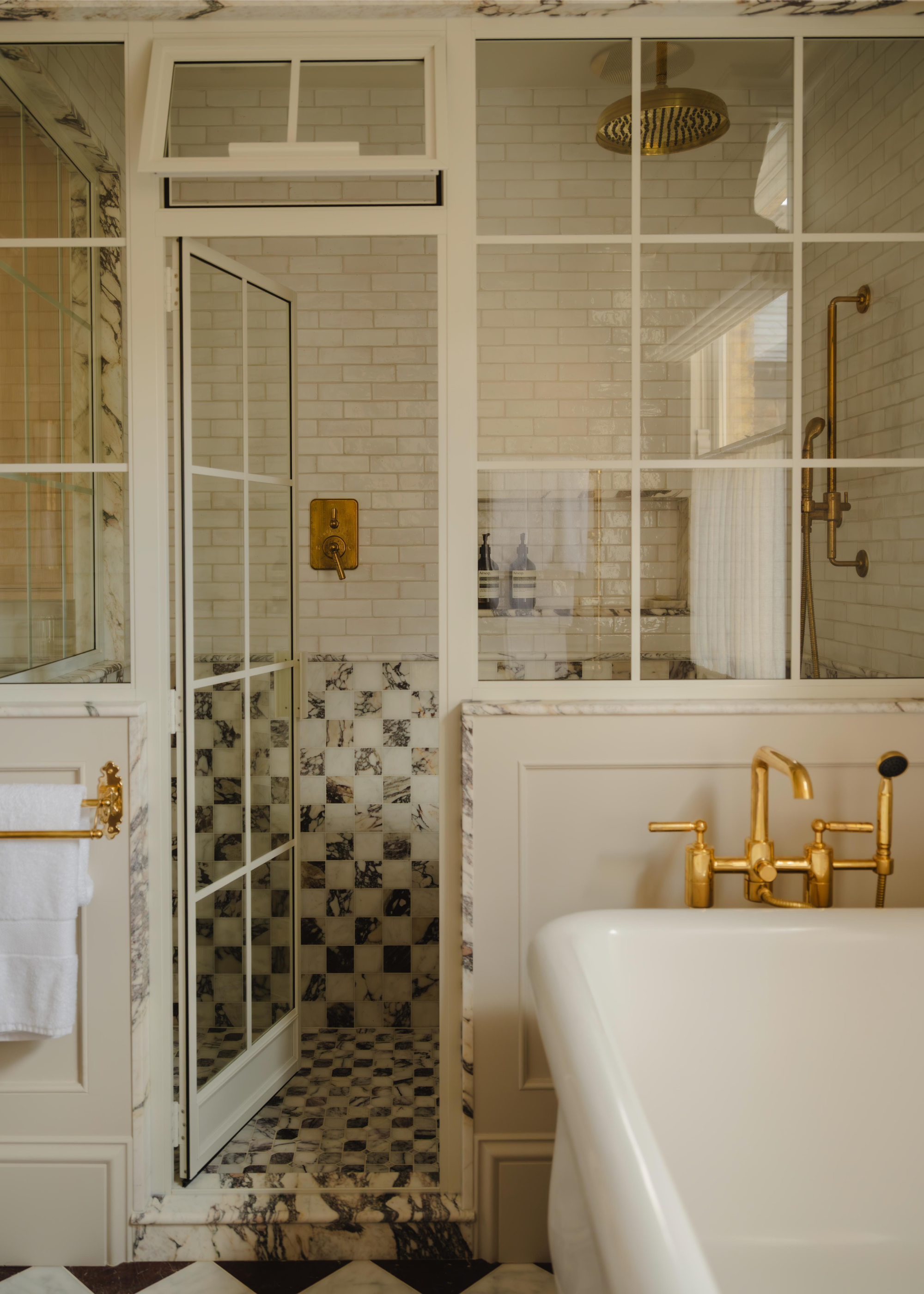 conservatory shower with marble checkered floors and half walls, and subway tile upper walls