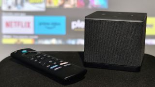 The Amazon Fire TV Cube and its remote over Fire TV.