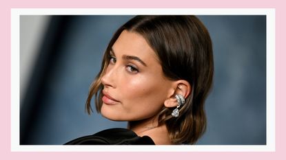 Hailey Rhode Bieber wears a black dress and silver earrings as she attends the 2023 Vanity Fair Oscar Party Hosted By Radhika Jones at Wallis Annenberg Center for the Performing Arts on March 12, 2023 in Beverly Hills, California./ in a pink template