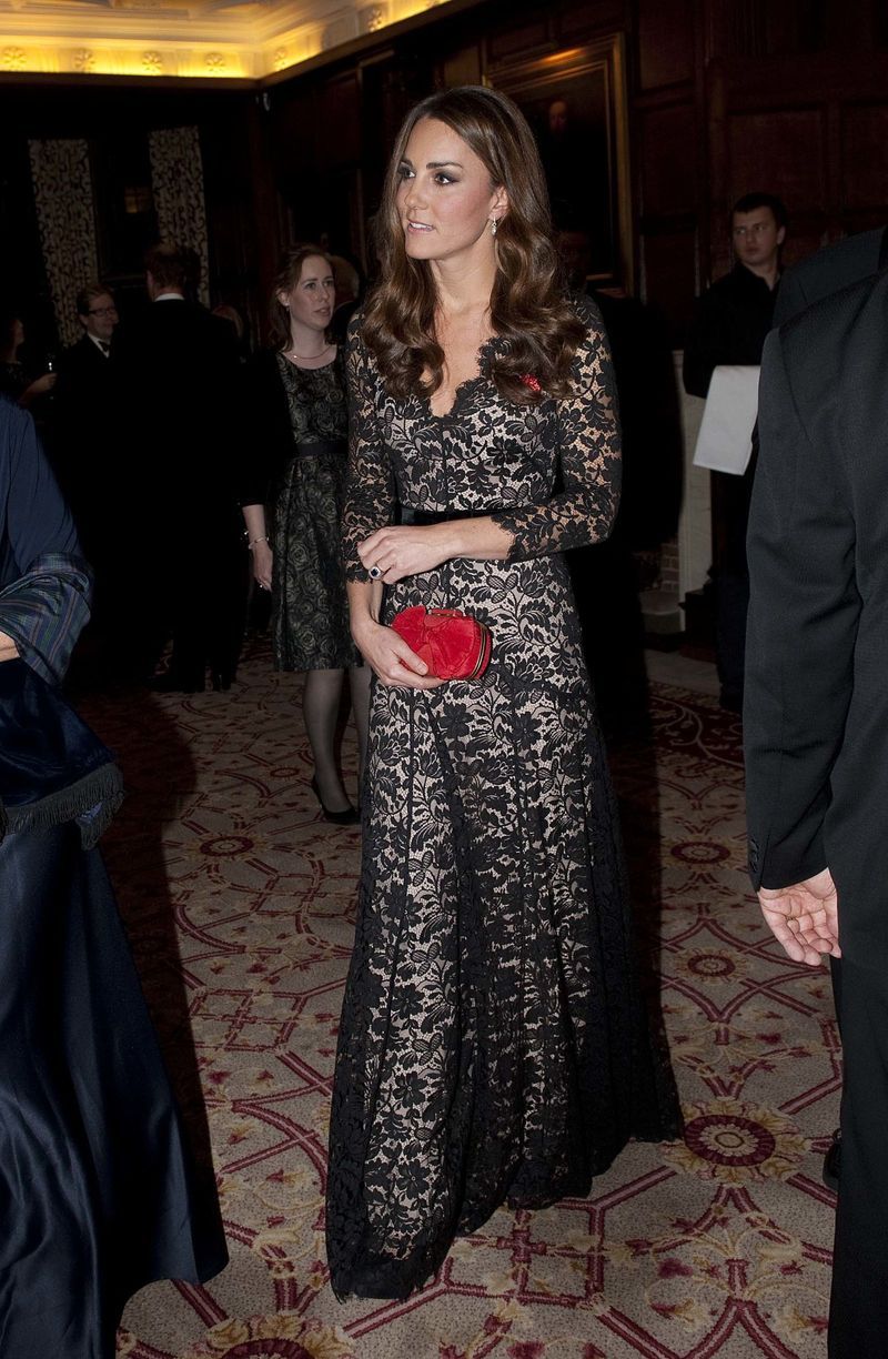 Wearing a black and nude lace gown by Temperley London (again!) for a dinner, she accessorizes with a red Alexander McQueen clutch for a pop of color.