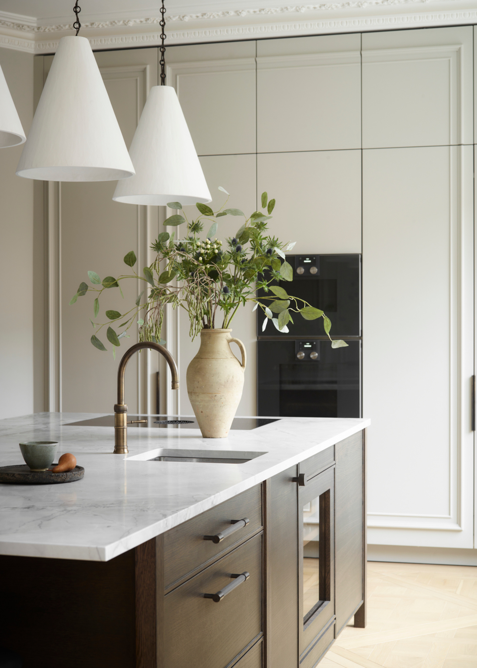 modern kitchen in period home with dark cabinet and marble counters