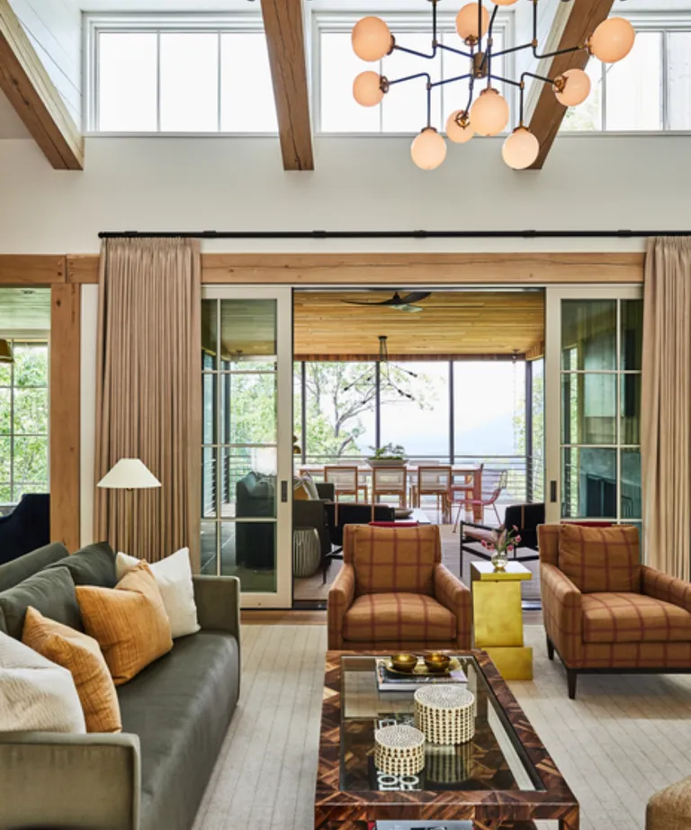 Modern country living room with check accent lounge chairs and glass coffee table with tortoiseshell detail