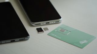 Mint Mobile SIM card next to two Android phones