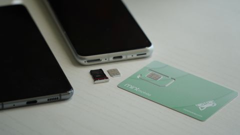 Mint Mobile SIM card near a phone with an open SIM tray