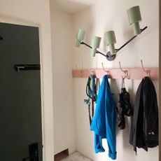 White porch with pink hooks and statement wall light