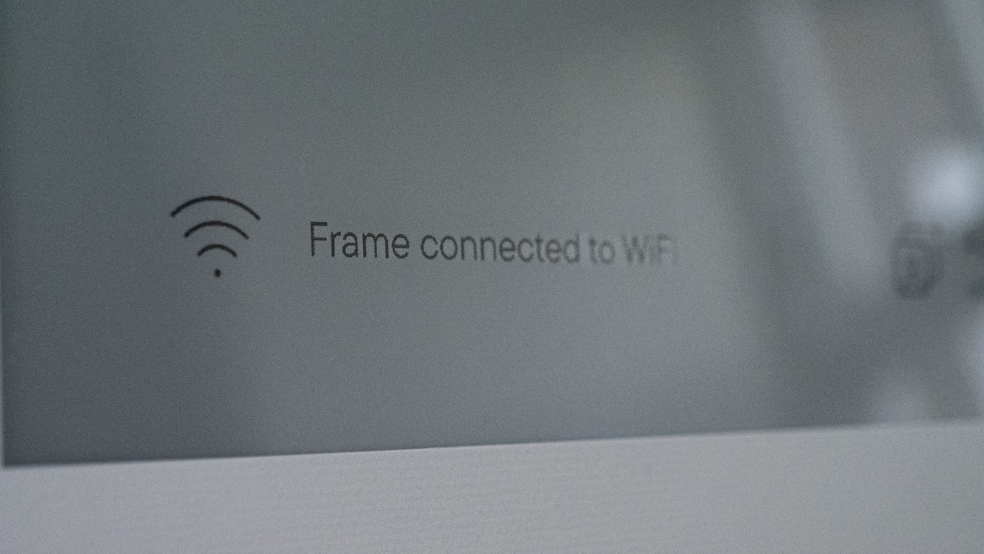 A closeup of the Aura Ink 'E Ink' digital photo frame's display, in pairing mode