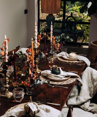 An autumnal tablescape with candlelit dining scene and oatmeal colored table napkins